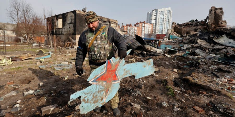 A Ukrainian fighter of the Territorial Defense Forces carries a piece of wreckage from a downed Russian Su-34 fighter-bomber in Chernihiv, on April 6, 2022 (illustrative image).