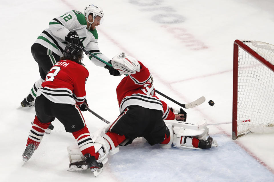 Dallas Stars center Radek Faksa (12) scores a goal past Chicago Blackhawks goaltender Kevin Lankinen (32) and Duncan Keith (2) during the third period of an NHL hockey game Tuesday, April 6, 2021, in Chicago. (AP Photo/Jeff Haynes)