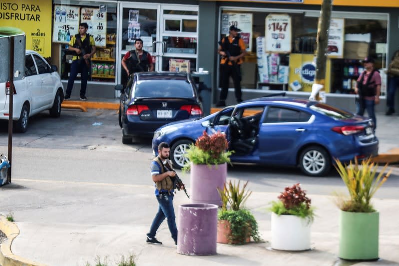 Cartel gunmen are seen outside during clashes with federal forces following the detention of Ovidio Guzman, son of drug kingpin Joaquin "El Chapo" Guzman, in Culiacan