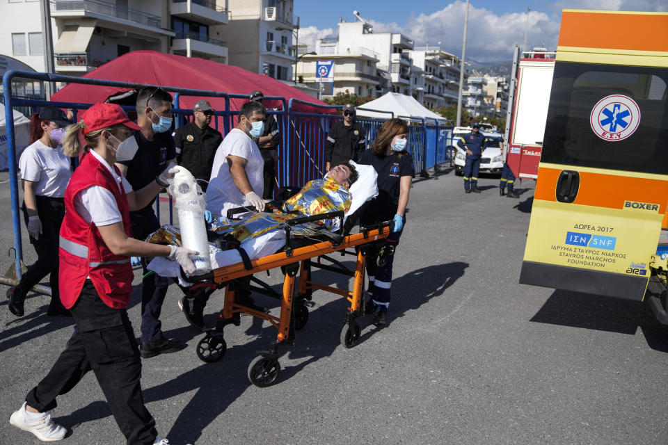 Paramedics carry an injured survivor of a shipwreck to an ambulance at the port in Kalamata town, about 240 kilometers (150miles) southwest of Athens on Wednesday, June 14, 2023. Authorities say at least 78 people have died and dozens are feared missing off the coast of southern Greece after a fishing boat carrying migrants capsized and sank.(AP Photos/Thanassis Stavrakis)