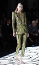 <b>Atelier Versace SS13 </b><br><br>This model donned a metallic suit, slashed to the navel, teamed with strappy heels and hooped earrings.<br><br>© Rex