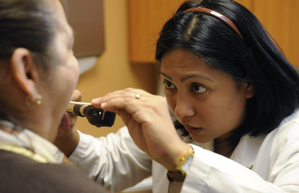 Dr. Millie Marie Tolentino (R) examines patient Dora Leon.