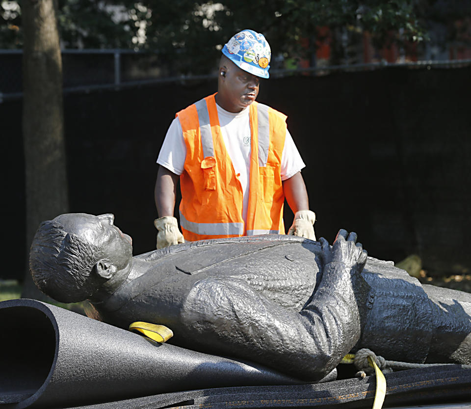 A workman looks at the statue of Harry F. Byrd, Sr., former Virginia Governor and U. S. Senator, lying on a pallett after it was removed from the pedestal in Capitol Square in Richmond, Va. Wednesday, July 7, 2021. The General Assembly approved the removal during the last session. (Bob Brown/Richmond Times-Dispatch via AP)
