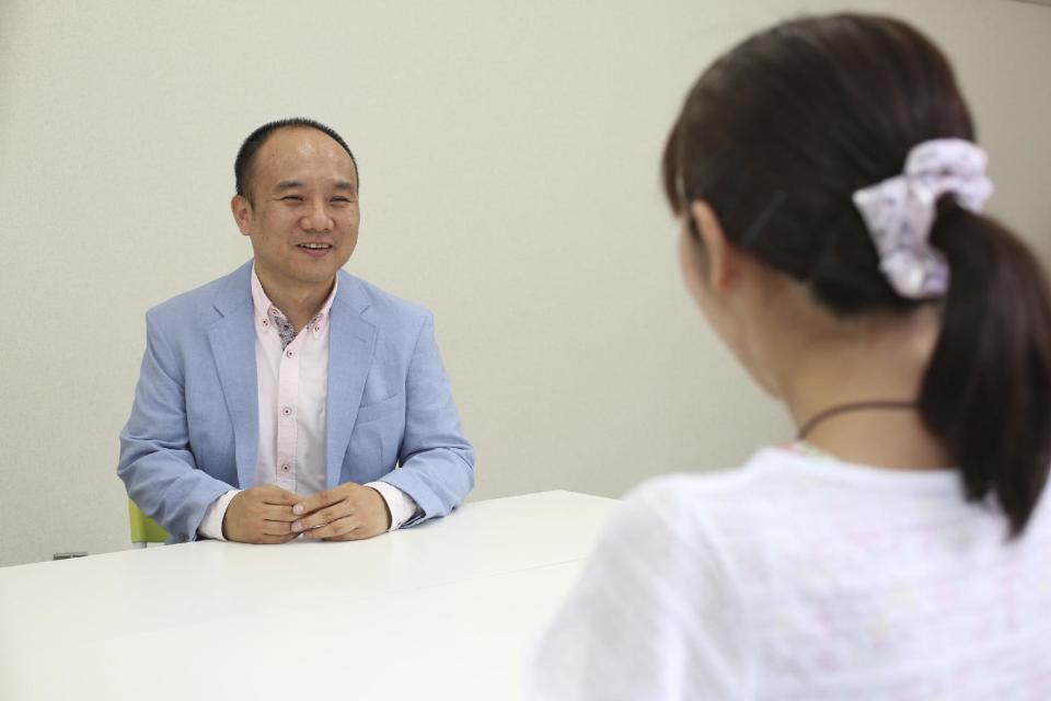 In this Aug. 2016 photo provided by Kazuo Sawato, Sawato, who has become a mental counselor after surviving his suicide attempt in 2005, talks to his client at a counseling room. The 31-year-old Japanese office worker ran to the roof's edge and jumped. He landed on his legs, and initially regretted surviving. Now 42, Sawato says he is glad to be alive and wants to share his journey back to the world of the living with others who struggle under the societal pressure that make Japan one of the world's most suicide-prone societies. (Kazuo Sawato via AP)