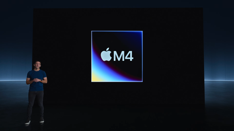جان ترنوس اپل در مقابل یک اسلاید دیجیتالی از تراشه M4 ایستاده است.