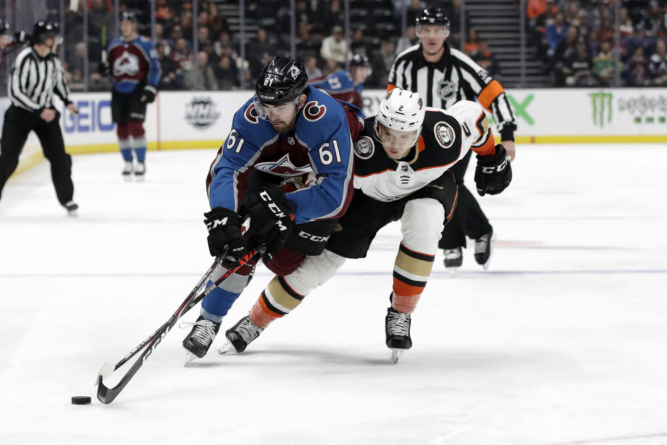 Colorado Avalanche's Martin Kaut, left, is defended by Anaheim Ducks' Brendan Guhle during the first period of an NHL hockey game Friday, Feb. 21, 2020, in Anaheim, Calif. (AP Photo/Marcio Jose Sanchez)