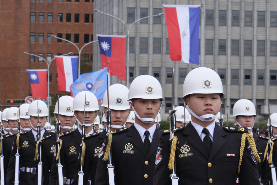Members of an honor guard stand in formation near Taiwanese and Paraguayan flags at the Presidential House in Taipei, Taiwan, Thursday, Feb. 16, 2023. The outgoing president of Paraguay, whose country is one of Taiwan's few remaining diplomatic allies, spoke of his admiration of the island's democracy Thursday while on a state visit. (AP Photo/Johnson Lai)