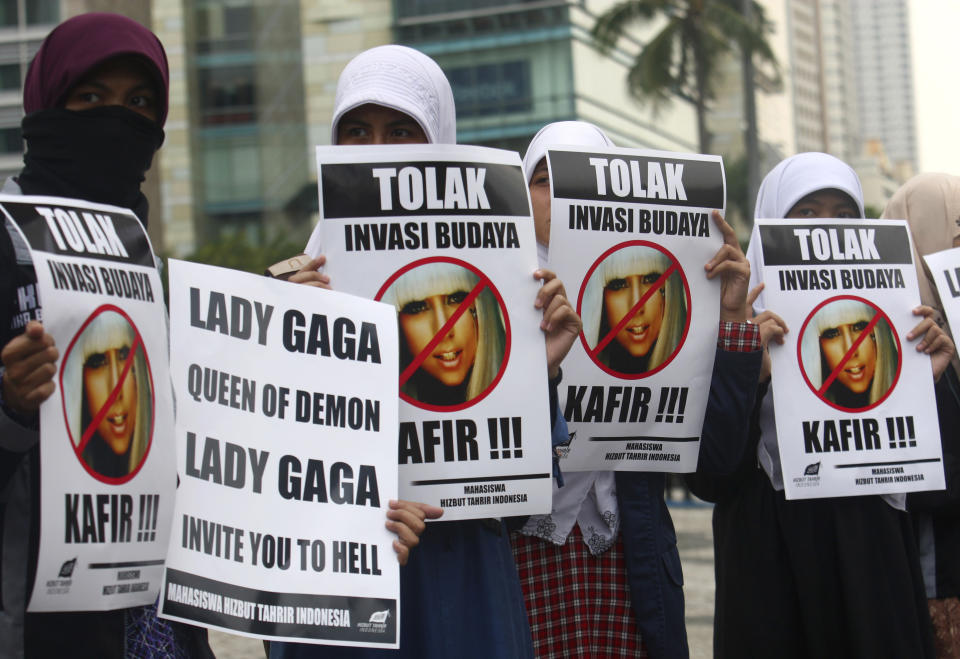 Muslim women hold posters during a protest against Lady Gaga's concert that is scheduled for June 3, in Jakarta, Indonesia, Thursday, May 24, 2012. Lady Gaga might have to cancel her sold-out show in Indonesia because police worry her sexy clothes and dance moves undermine Islamic values and will corrupt the country's youth. The writings on the posters read "Reject cultural invasion" and "Infidel." (AP Photo/Tatan Syuflana)