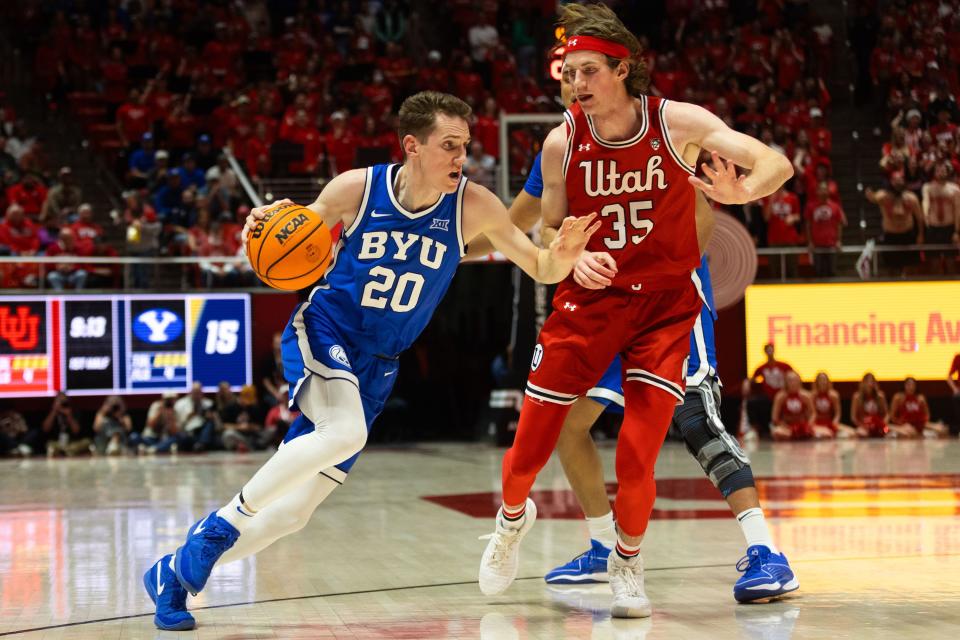 Brigham Young Cougars guard Spencer Johnson (20) drives the ball with Utah Utes center Branden Carlson (35) on defense during a men’s basketball game at the Jon M. Huntsman Center in Salt Lake City on Saturday, Dec. 9, 2023.