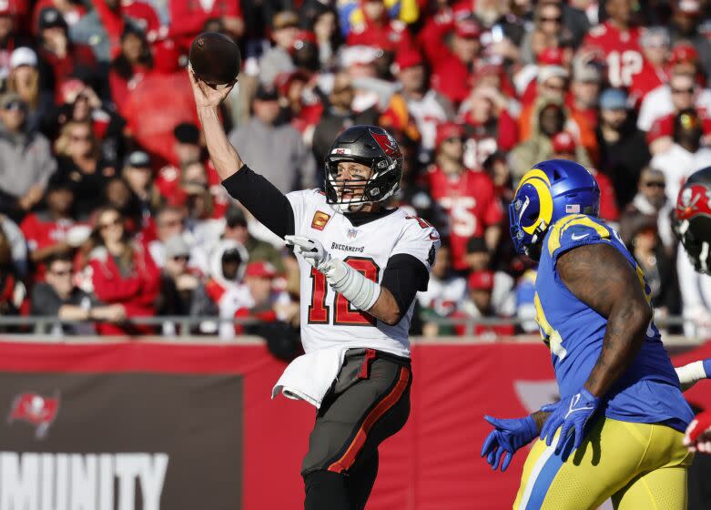 TAMPA BAY, FL- JANUARY 23, 2022: Tampa Bay Buccaneers quarterback Tom Brady (12) makes a pass against Los Angeles Rams defensive end A'Shawn Robinson (94) in the NFC Divisional game at Raymond James Stadium on January 23, 2022 in Tampa Bay, Florida. He announced today that he is retiring after 22 years in the NFL.(Gina Ferazzi / Los Angeles Times)