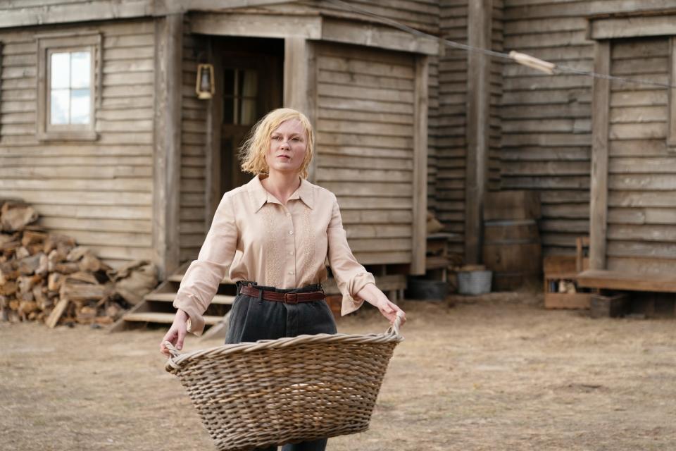 Kirsten Dunst holds a laundry basket