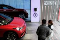 FILE PHOTO: People check a Volkswagen ID.4 X electric vehicle inside an ID. Store X showroom of SAIC Volkswagen in Chengdu