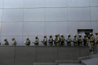 Soldiers return to the government palace after lowering the Bolivian national flag at Murillo square in La Paz, Bolivia, Friday, June 28, 2024, two days after Army troops stormed the government palace in what Bolivia's President Luis Arce called a coup attempt. (AP Photo/Juan Karita)