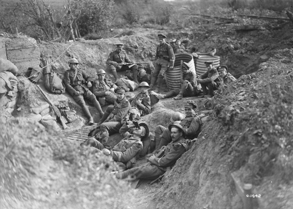 The 22nd (French Canadian) Battalion resting in a shell hole on their way to the front line. Sept. 1917
