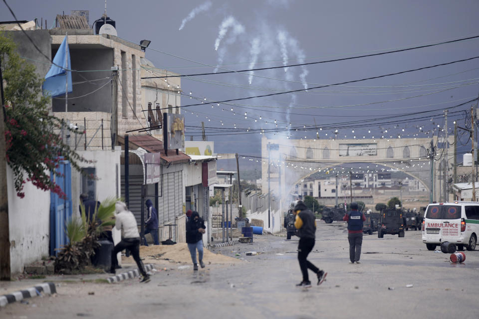 Palestinians run from tear gas fired by Israeli forces raiding Aqbat Jabr camp, southwest of the city of Jericho on Saturday, Feb. 4, 2023, during a search for the Palestinian suspects behind a shooting attack at a restaurant in a nearby settlement last week. The army said it surrounded several residences that Palestinians were using to hide out and plan future attacks and ultimately arrested several suspects who surrendered. During the raid, the army said Palestinian protesters shot at Israeli security forces, who responded with live fire. The Palestinian Health Ministry said six people were wounded, two seriously. (AP Photo/ Majdi Mohammed)Palestinians clashes with Israeli forces during during a military raid the West Bank Aqabat Jaber camp near Jericho, Saturday, Feb. 4, 2023. (AP Photo/Majdi Mohammed)