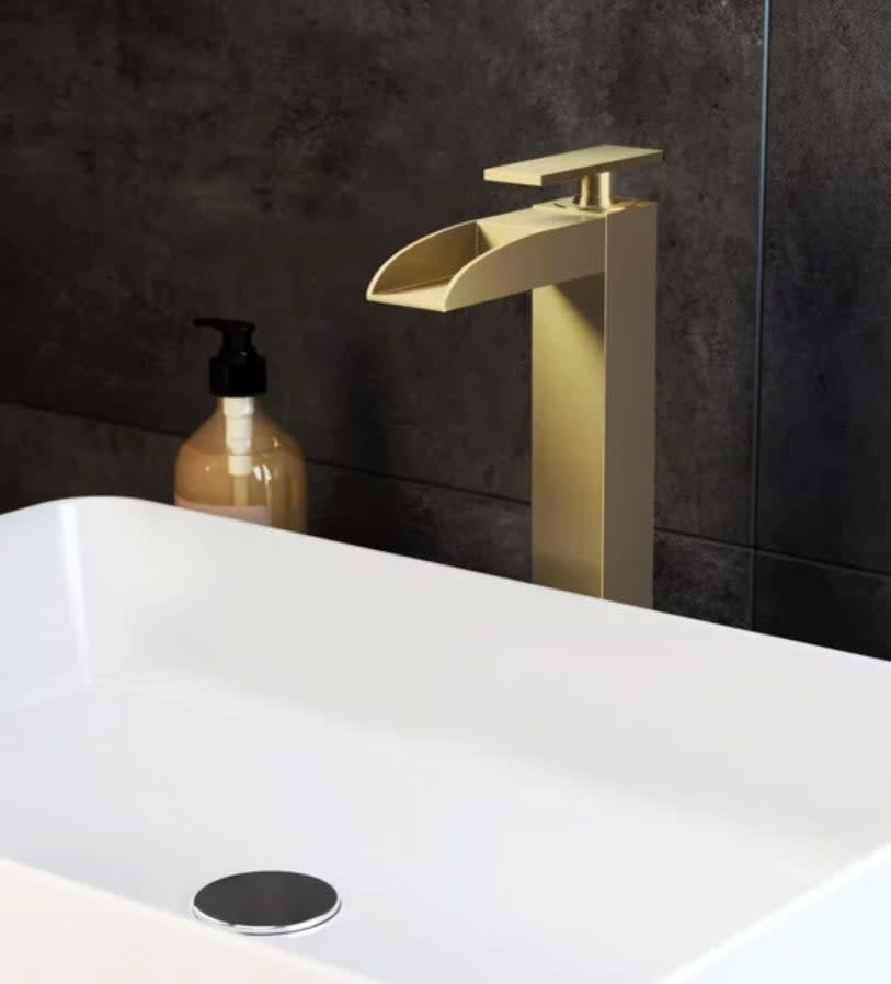 gold waterfall faucet over sink