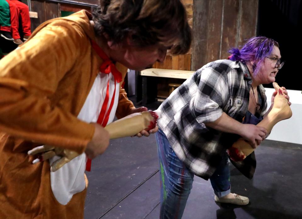 Zombies Dawn Livingston, left and Amanda Sullivan, right munch on some body parts during play practice for "Twas the Bite Before Christmas" on Monday, Nov. 28, 2022.