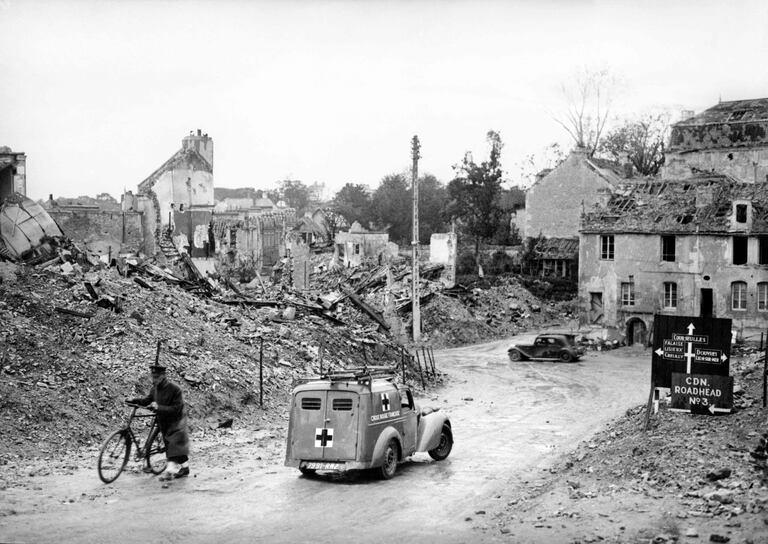  Un vehículo de la Cruz Roja Francesa avanza por las calles sembradas de escombros de Caen, Normandía, norte de Francia, el 4 de octubre de 1944, durante la Segunda Guerra Mundial.