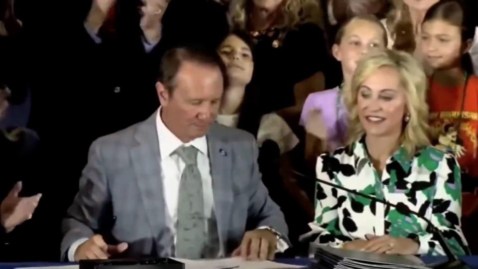 A student appears to faint as Louisiana Governor Jeff Landry signs legislation on June 19 that forces public schools to hand the Ten Commandments in every classroom (WBRZ)