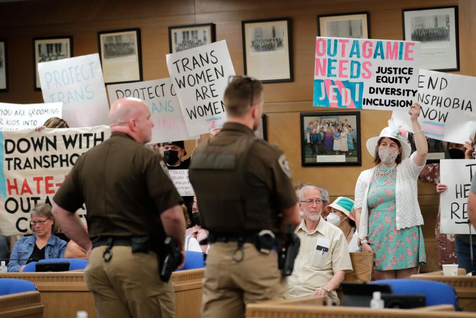 Deputies keep stand in front of transgender rights activists and citizens as they disrupt an Outagamie County Board meeting at the Outagamie County Government Center on Tuesday, May 23, 2023, in Appleton, Wis. At a May 9 county board meeting, board member Timothy Hermes made transphobic comments regarding transgender people and their use of bathrooms that align with their gender, calling them "disgusting."