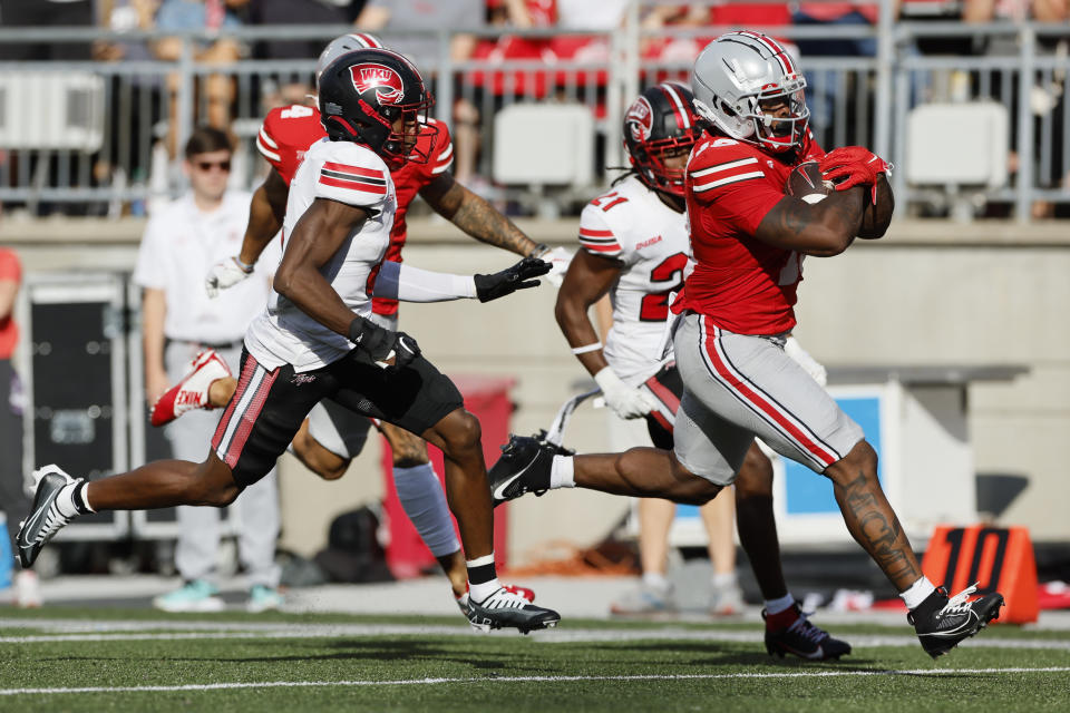 Ohio State running back Chip Trayanum, right, scores a touchdown past Western Kentucky defenders during the first half of an NCAA college football game, Saturday, Sept. 16, 2023, in Columbus, Ohio. (AP Photo/Jay LaPrete)