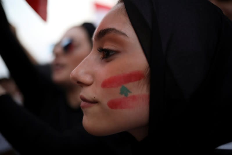 A demonstrator with a Lebanese national flag drawn on her face takes part in an anti-government protest in downtown Beirut