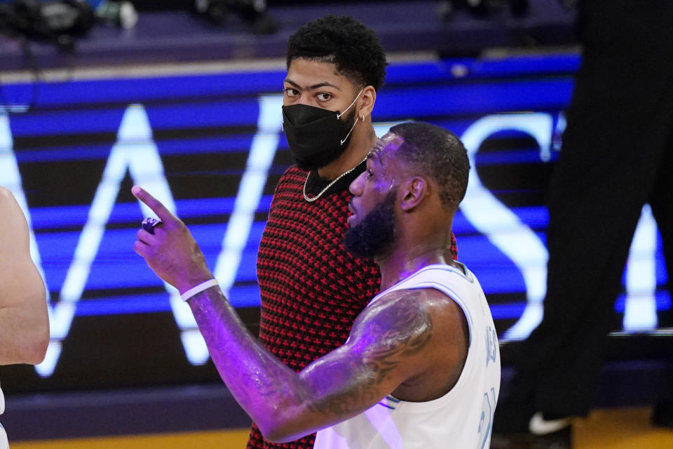 Los Angeles Lakers forward LeBron James, right, talks with Anthony Davis during the first half of an NBA basketball game against the Washington Wizards Monday, Feb. 22, 2021, in Los Angeles. (AP Photo/Mark J. Terrill)