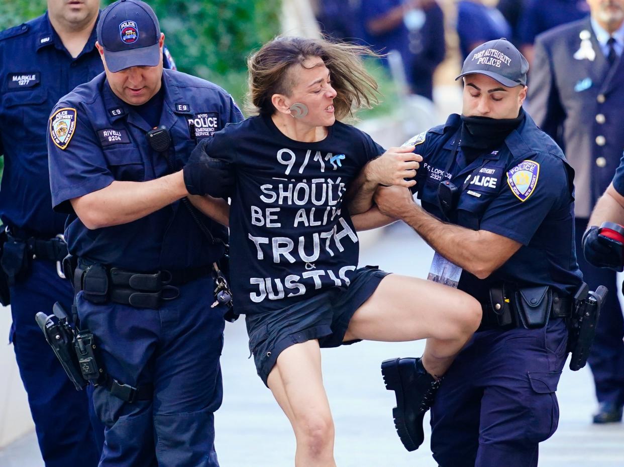 A person is detained near the National September 11 Memorial & Museum during a ceremony marking the 20th anniversary of the 9/11 terrorist attacks, on September 11, 2021  (AP)