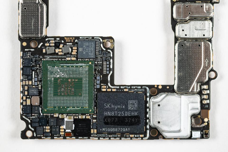 Components of a Huawei Mate X5 smartphone, including a Kirin 9000s chip fabricated in China.