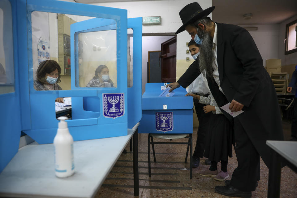 An Ultra-Orthodox Jewish man votes for Israel's parliamentary election at a polling station in Bnei Brak, Israel, Tuesday, March. 23, 2021. Israel is holding its fourth election in less than two years. (AP Photo/Oded Balilty)