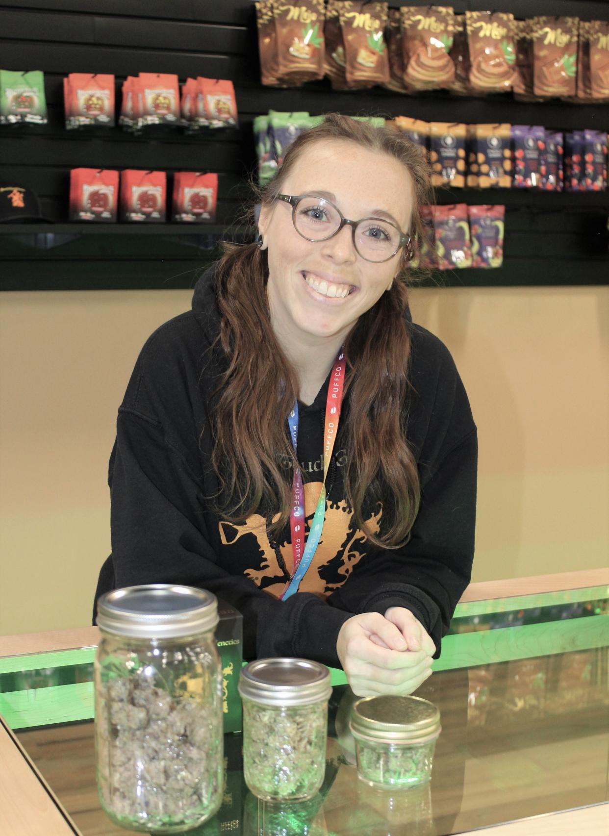 Hilary “Hilly” Donbrosky, a bud-tender at Green Labs Provisions, displays some of the medical marijuana products offered at the Luna Pier dispensary. Open seven days a week, customers must be 18 or older and have valid identification and a medical marijuana card.