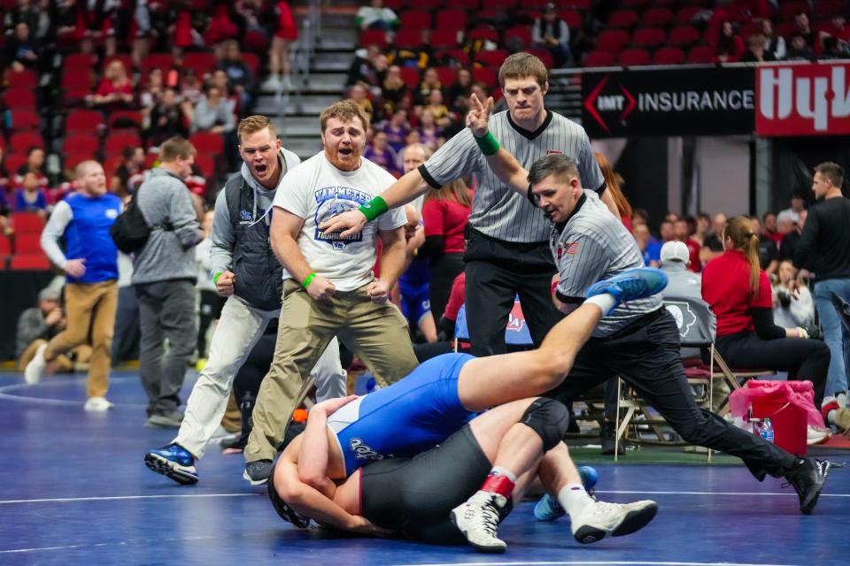 Van Meter’s coaches celebrate Jackson Boese defeating Clarinda’s Karson Downey in overtime at 182 pounds during the Class 2A quarterfinals of the Iowa high school state wrestling tournament at Wells Fargo Arena in Des Moines on Thursday, Feb. 16, 2023.