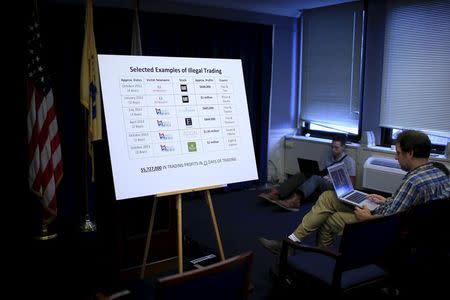 Journalist works next to a poster with information about illegal trading after a news conference in Newark, New Jersey August 11, 2015. REUTERS/Eduardo Munoz