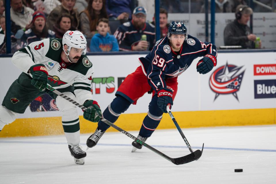 Jan 6, 2024; Columbus, Ohio, USA;
Columbus Blue Jackets right wing Yegor Chinakhov (59) races Minnesota Wild defenseman Jake Middleton (5) to the puck during the third period of their game on Saturday, Jan. 6, 2024 at Nationwide Arena.