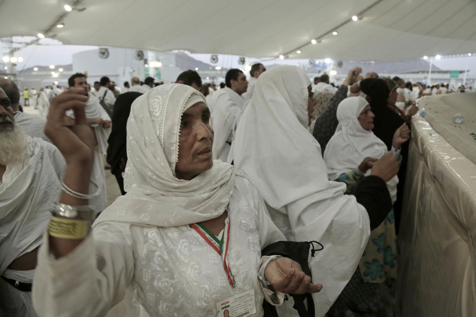 FILE - In this Sept. 12, 2016 file photo, Indian women cast stones at a pillar symbolizing the stoning of Satan, in a ritual called "Jamarat," the last rite of the annual hajj, on the first day of Eid al-Adha, in Mina near the holy city of Mecca, Saudi Arabia. (AP Photo/Nariman El-Mofty, File)