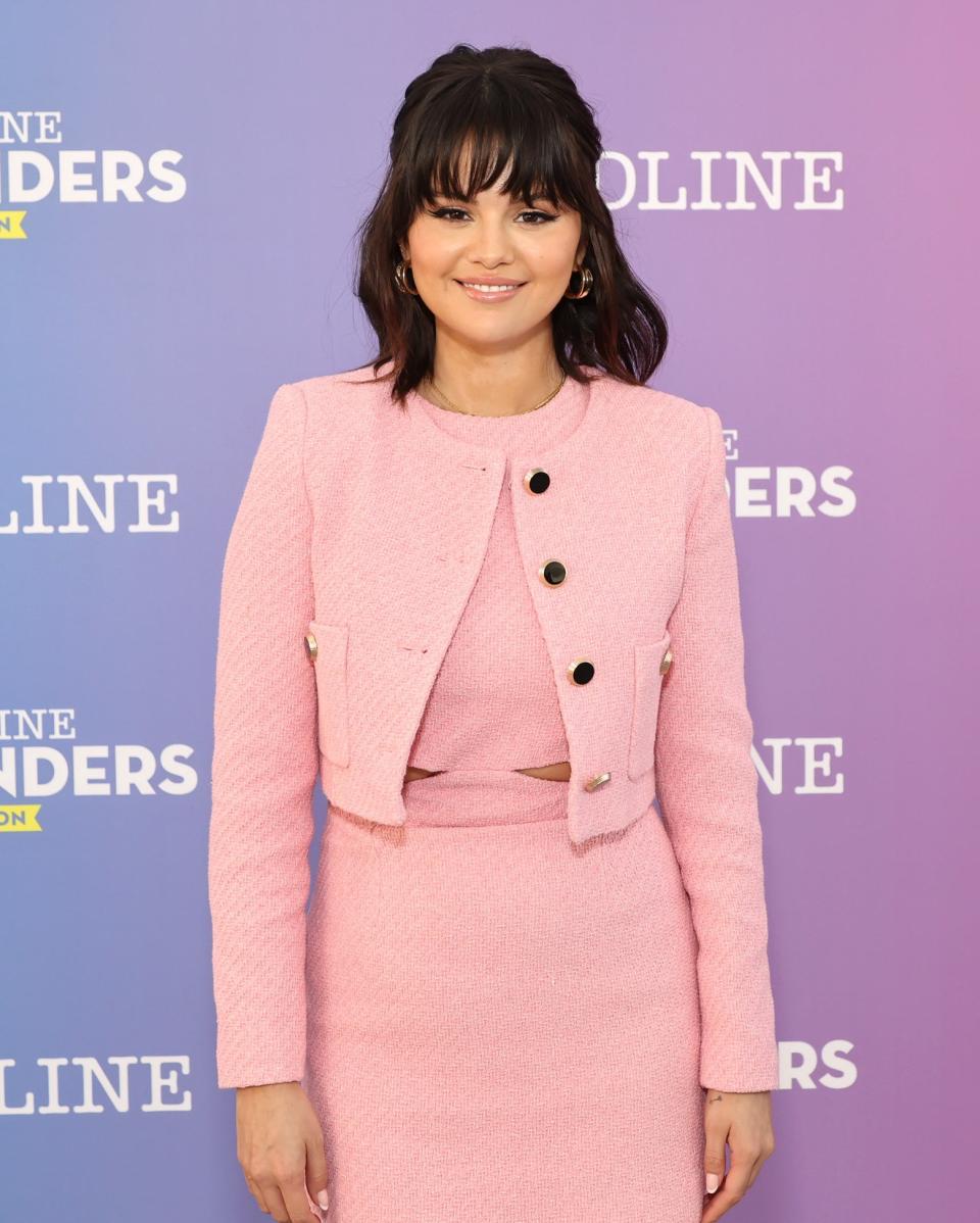 Selena at an event wearing a matching skirt suit with short hair and bangs