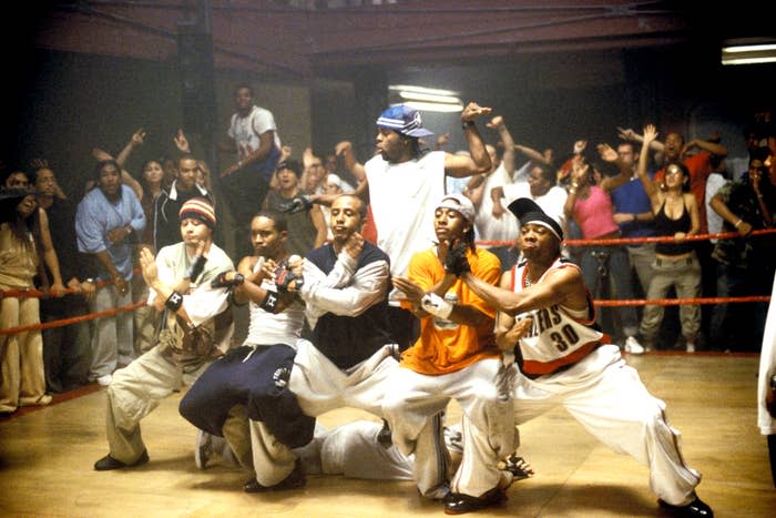 Group of dancers battling in a dance-off scene, with onlookers surrounding the area