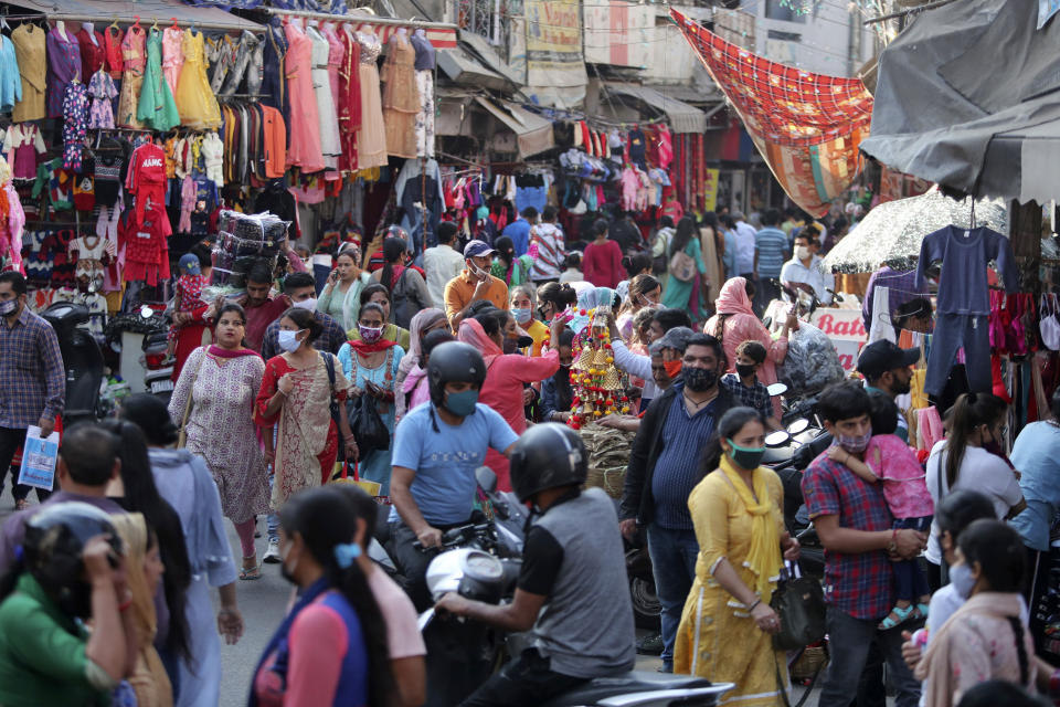 People wearing masks as a precaution against the coronavirus shop at a market upcoming Hindu festival Karwa Chauth in Jammu, India, Monday, Nov. 2, 2020. Married Hindu women eat this traditionally prepared food in the wee hours of the morning and fast till dusk during the festival, praying for health and long life of their husbands. (AP Photo/Channi Anand)