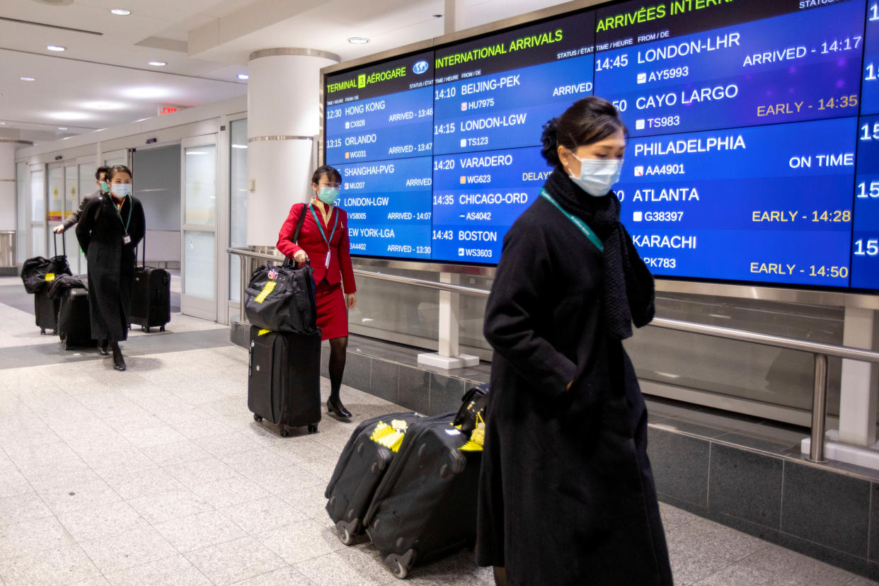 Flight crew members wear masks at Pearson airport arrivals, shortly after Toronto Public Health received notification of Canada's first presumptive confirmed case of coronavirus, in Toronto, Ontario, Canada January 26, 2020. REUTERS/Carlos Osorio