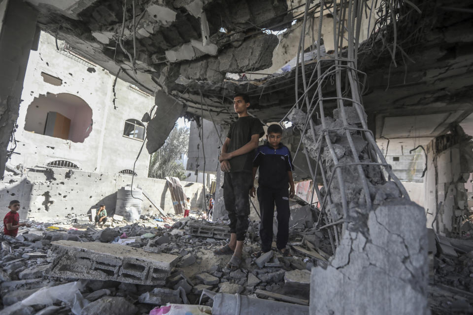 Palestinians stand in the ruins of the Chahine family home, after an overnight Israeli strike that killed at least two adults and five boys and girls under the age of 16 in Rafah, southern Gaza Strip, Friday, May 3, 2024. An Israeli strike on the city of Rafah on the southern edge of the Gaza Strip killed several people, including children, hospital officials said Friday. (AP Photo/Ismael Abu Dayyah)