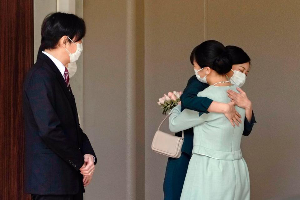 Princess Mako, right, hugs her sister Princess Kako, as their parents Crown Prince Akishino and Crown Princess Kiko watch, before leaving her home in the Akasaka estate, Tokyo (Kyodo News)