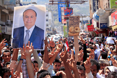 FILE PHOTO: Protesters hold up a poster of Yemeni President Abd-Rabbu Mansour Hadi during a protest against the deteriorating economy in Taiz, Yemen, October 4, 2018. REUTERS/Anees Mahyoub/File Photo