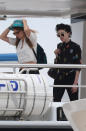 It looks like Delevingne, the model-turned-actress, is attempting to keep her hat from flying off deck. She didn’t stray from her casual-cool style, however, wearing ripped jeans and a crop-top. Her pal (or girlfriend?) wore a black shirt with playful polka dots and oversized yellow sunglasses.