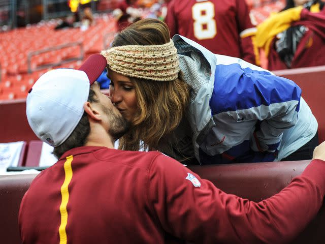 <p>The Washington Post/Getty </p> Kirk Cousins (8) kisses his wife Julie Cousins