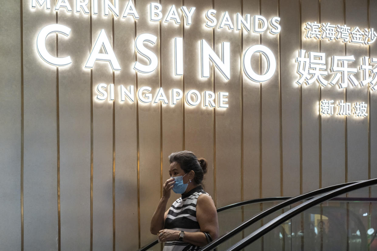 SINGAPORE, SINGAPORE - JULY 07: A woman wearing a protective face mask walks past a Marina Bay Sands Casino signage on July 07, 2020 in Singapore. Residents will go to the polls to elect members of parliament on July 10. (Photo by Ore Huiying/Getty Images)