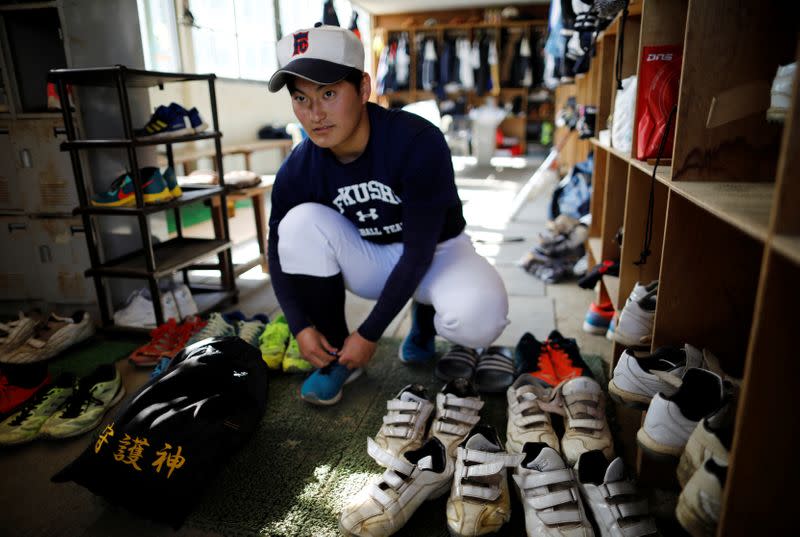 Ryoma Ouchi, an ace pitcher at Fukushima Commercial High School baseball team from Iitate, prepares for a workout at the clubhouse of the team in Fukushima, Japan