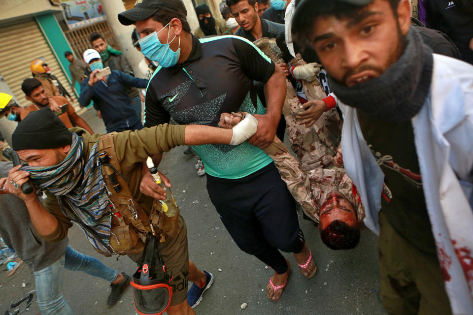 A soldier badly wounded during clashes with anti-government protesters is carried to a hospital during the ongoing protests in Rasheed Street, Baghdad, Iraq, Tuesday, Nov. 26, 2019. (AP Photo/Khalid Mohammed)