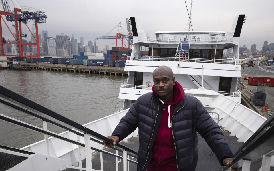 In this Nov. 30, 2018 photo, cruise boat owner Dwayne Braithwaite poses on his boat at a Brooklyn dock in New York. Braithwaite has filed a lawsuit alleging racism and accused the city contractor that runs the docks of punishing him for not paying kickbacks. The city and its contractor, Dock NYC, say Braithwaite and his vessels violated the terms of their docking contracts at least seven times in 77 days - departing late, blasting loud music and blocking commuter ferries by tying up in the wrong spot. Braithwaite will be in a New York City court room on Wednesday, Dec. 19. (AP Photo/Mark Lennihan)