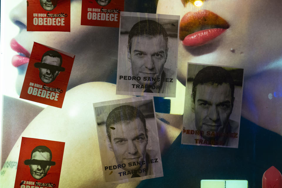 Posters against Spain's Prime Minister and Socialist Party Leader Pedro Sanchez are seen during a protest against the amnesty, outside the headquarters of Socialist Party in Madrid, Spain, Friday, Nov. 10, 2023. Spain's Socialist Party has struck a deal with a fringe Catalan separatist party to grant an amnesty for people involved in the region's failed secession bid, sparking a protest outside the party's headquarters. (AP Photo/Joan Mateu Parra)