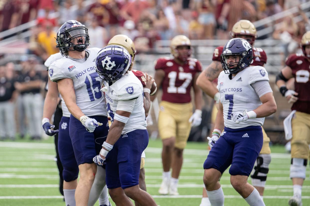 Holy Cross’s Jake Jarmolowich, left, Stu Smith, center, and Frankie Monte celebrate a defensive stop versus Boston College on Saturday September 9, 2023 at Alumni Stadium in Newton.